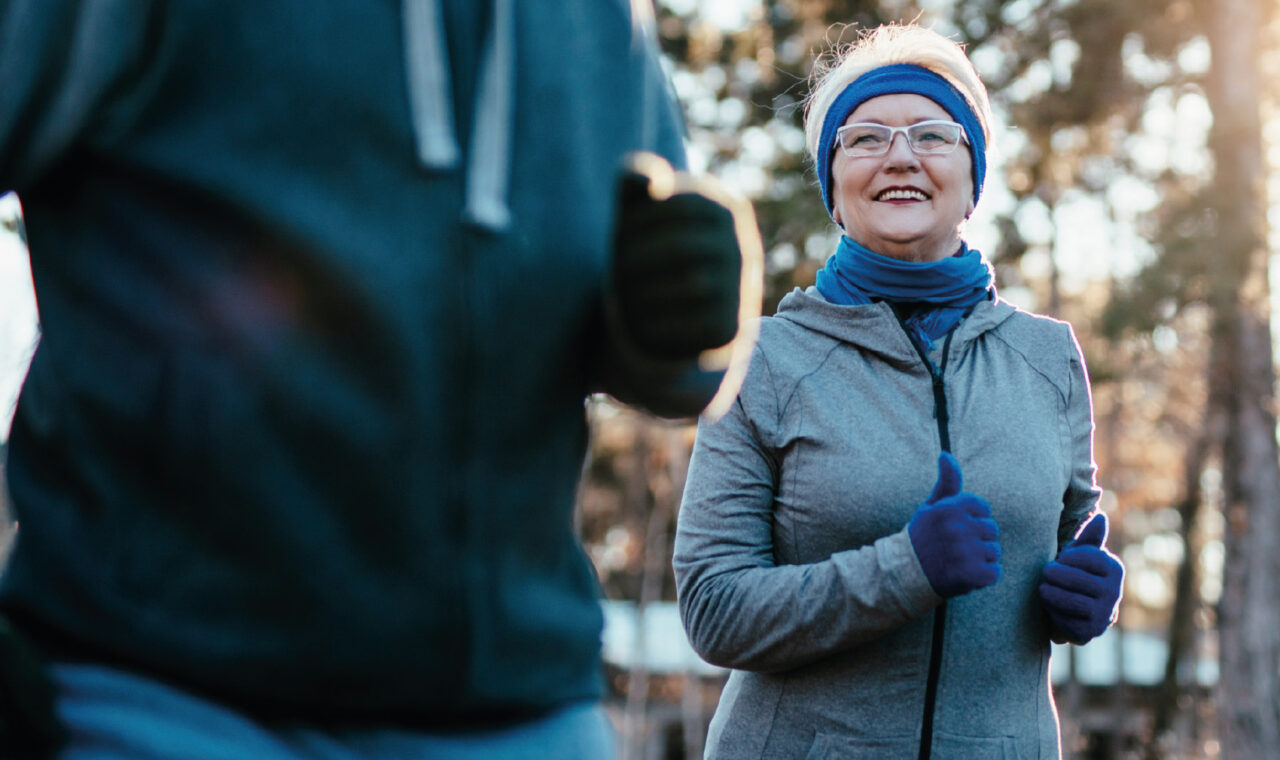 Eine Rentnerin und ein Begleiter beim Jogging im Winter