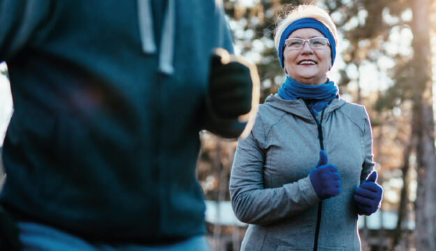Eine Rentnerin und ein Begleiter beim Jogging im Winter